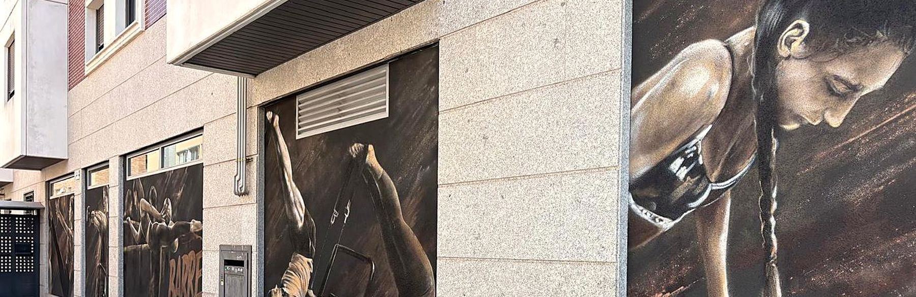 Fachada de Energy Lab&Fit con los murales del centro